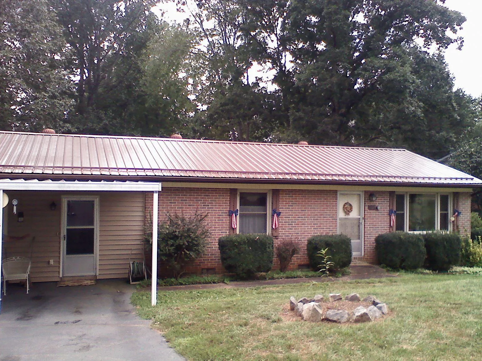 Bronze metal roof and carport on a brick ranch home — Roof Repair work by our crew in Selma