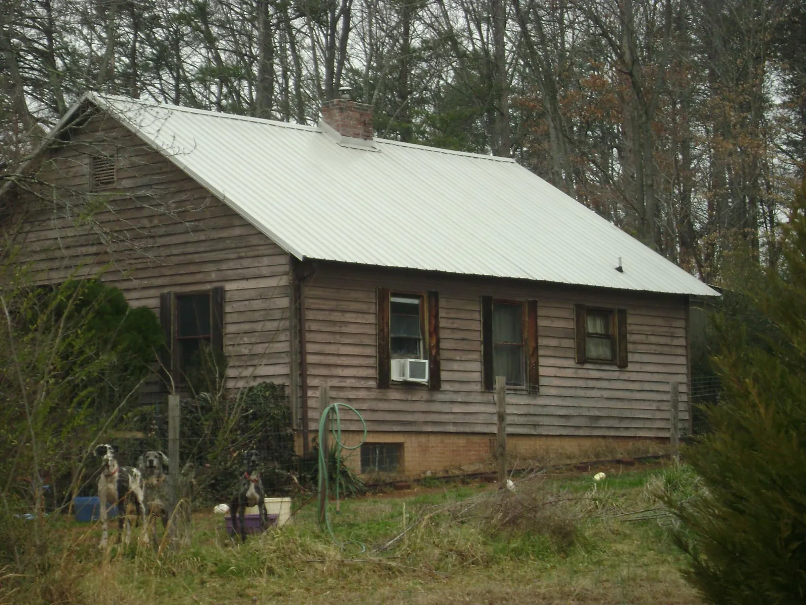 White metal roof on an old wood sided farmhouse, from a Metal Roof Installation job in Selma